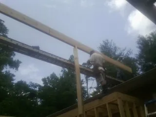 Carpenter setting a ridge beam over a new addition frame — Ice Dam Removal by Roofing Brothers in Folkston