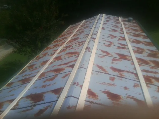 Rusted metal roof panels with new wood purlins before replacement — Storm Damage Roof Repair in Folkston by Roofing Brothers