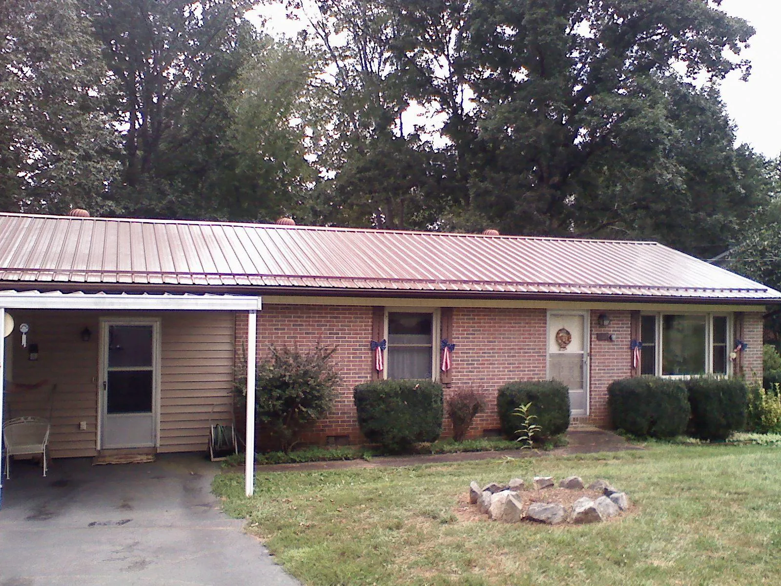 Bronze metal roof and carport on a brick ranch home — Roof Repair work by our crew in Folkston