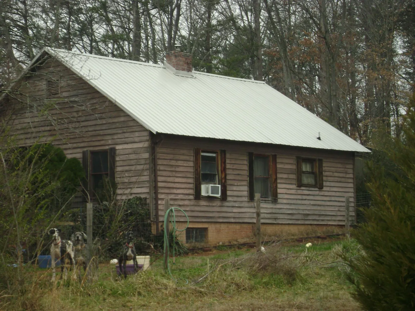 White metal roof on an old wood sided farmhouse, from a Metal Roof Installation job in Folkston